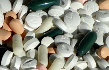 image of some miscellaneous medication, with white, orange, pink, and green colored pills in different shapes and sizes 