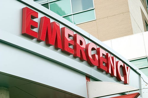 a red sign outside of a hospital that says EMERGENCY