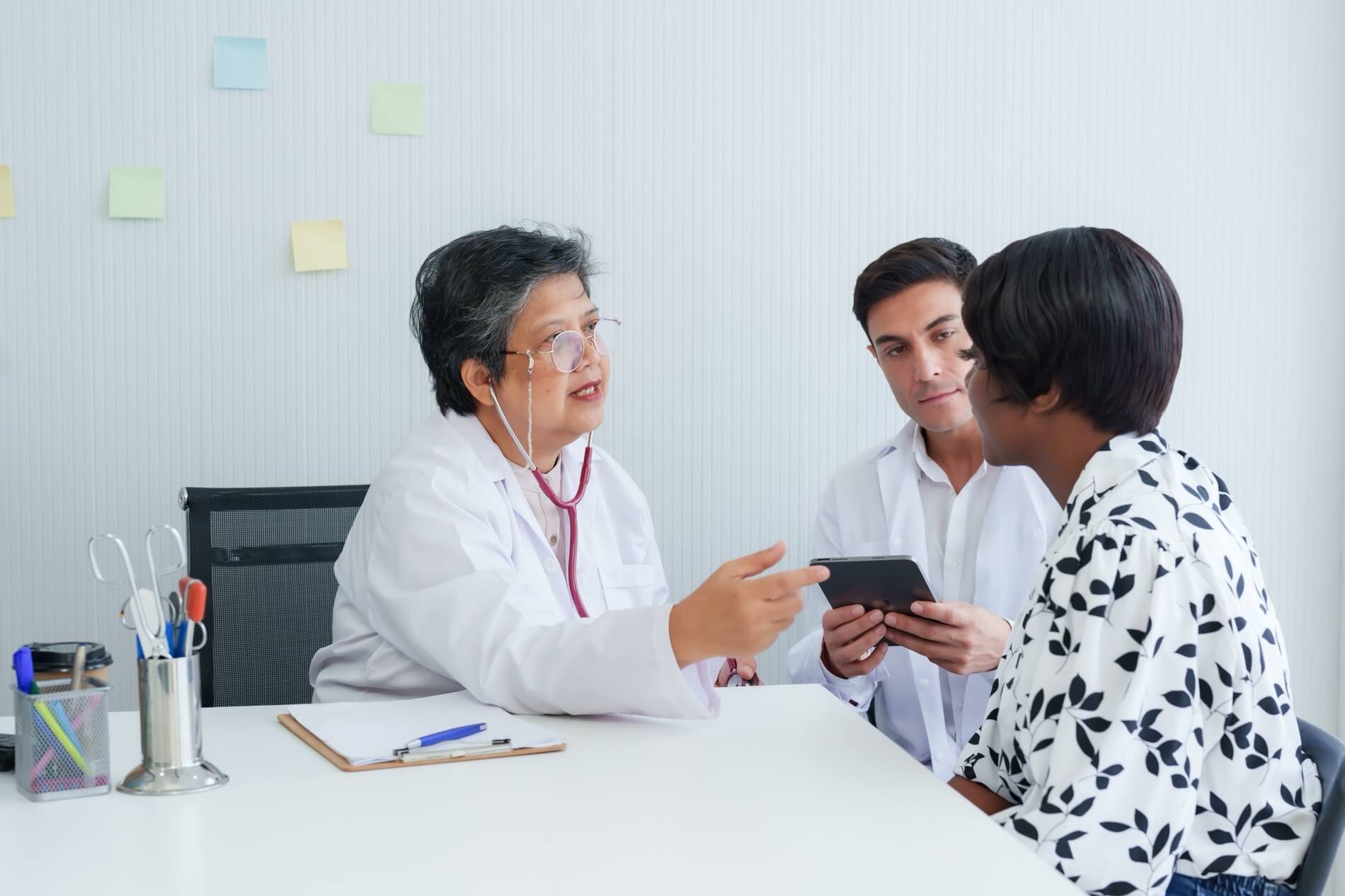 Two doctors explaining something to a patient.